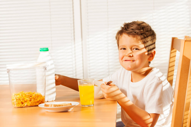 boy eating cereals and drinking juice - 写真・画像