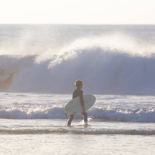 Surfers op strand met surfboard. - Foto, afbeelding