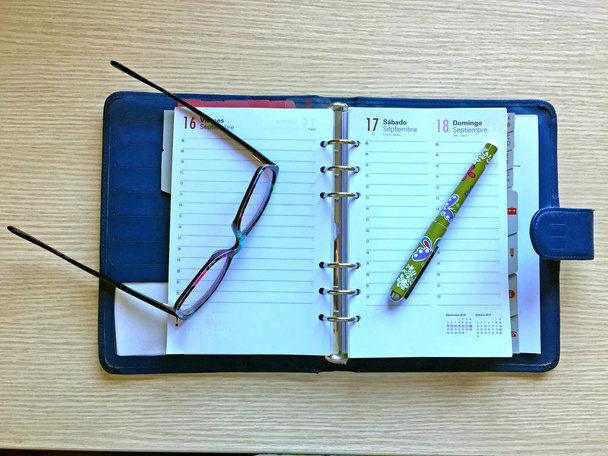 Bureau met glazen, dagboek en potlood - Foto, afbeelding