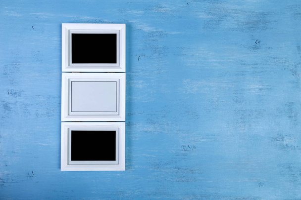 Blank photo frames on blue wood background. - Foto, imagen