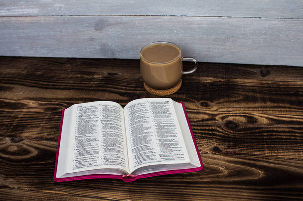 bible and coffee with milk on wooden background - 写真・画像