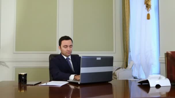 Someone disturbs businessman work, but he continues work with laptop - Záběry, video