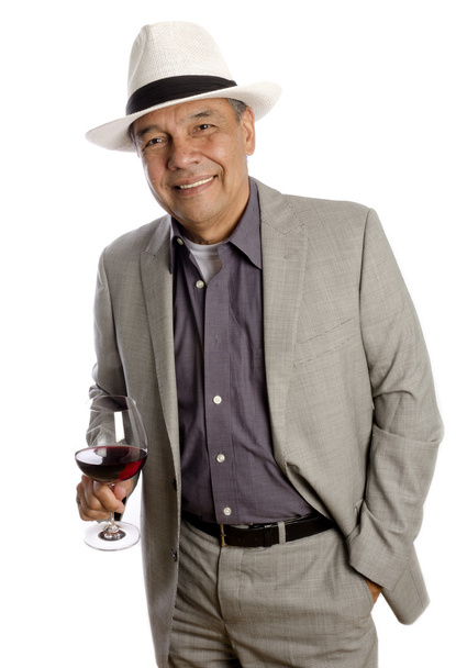Hispanic Mature Man in Suit and Hat Holding a Glass of Red Wine - Foto, afbeelding