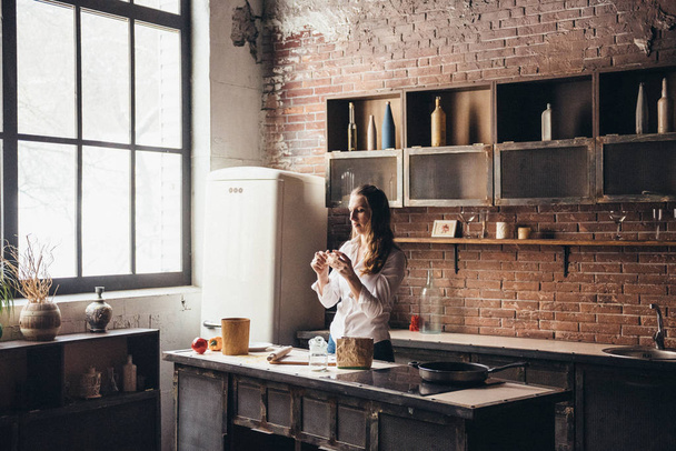 A girl in the kitchen prepares a dough - Foto, afbeelding