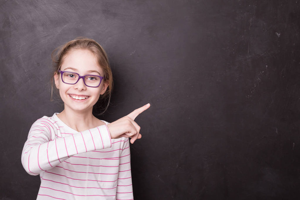 School - child girl (kid, pupil) pointing at the blackboard - Foto, Imagen