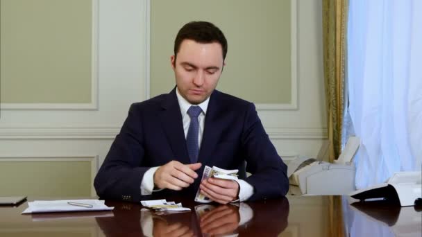 Confident businessman counts money and making notes - Video