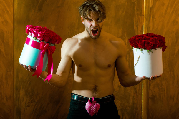 bearded muscular man with sexy body holds red rose box - Foto, immagini
