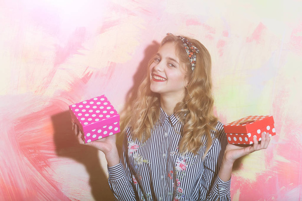 Cheerful girl with two red and pink polkadot gift boxes - Foto, immagini