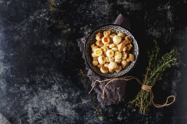 Mushrooms fried in a dish with thyme. Dark background. - Valokuva, kuva