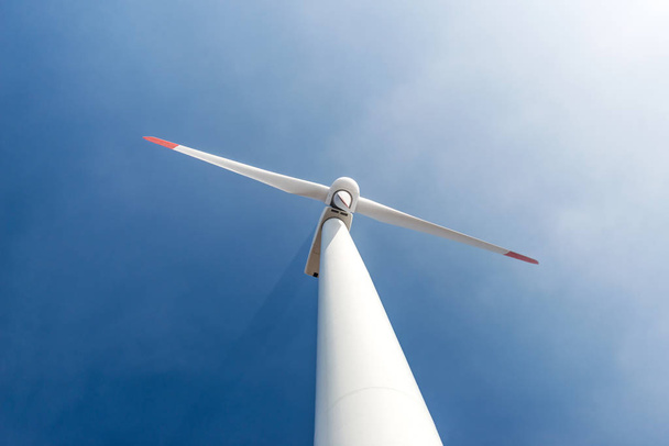 Ветровые турбины против голубого неба, генерирующего электричество
 - Фото, изображение