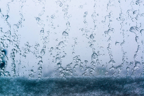 snow and water drops on the window glass - Foto, afbeelding