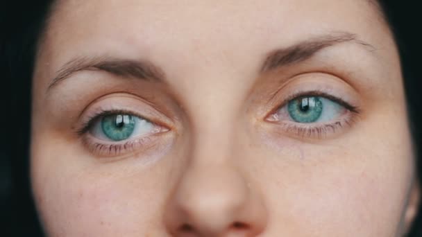 Green-eyed female face looks away and up to the camera. close-up view with sad girl - Footage, Video