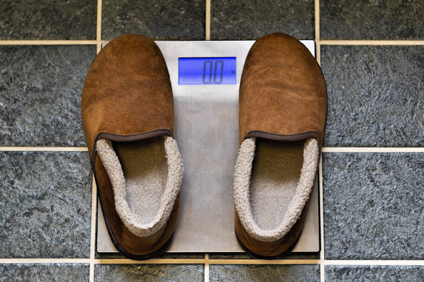 Zapatillas en una escala de peso
 - Foto, Imagen