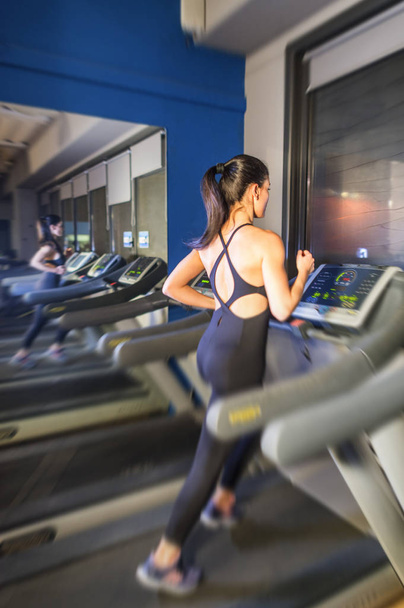 Menina correndo fazendo cardio em esteira na academia do centro de fitness
 - Foto, Imagem