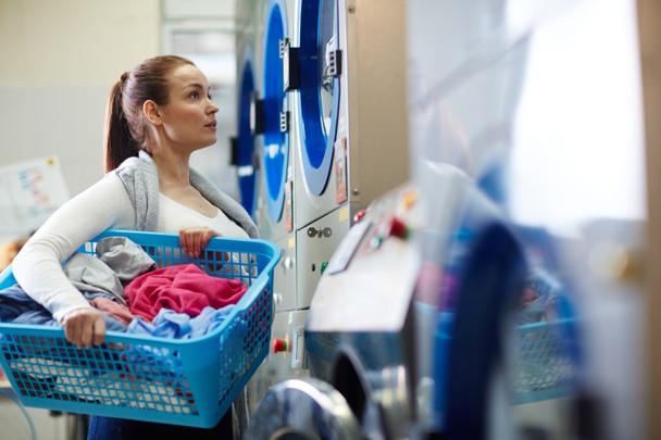 Kobieta z kosz na pranie w pralni - Zdjęcie, obraz