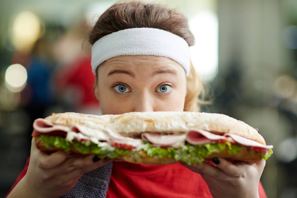 mujer con sobrepeso sosteniendo sándwich
 - Foto, imagen
