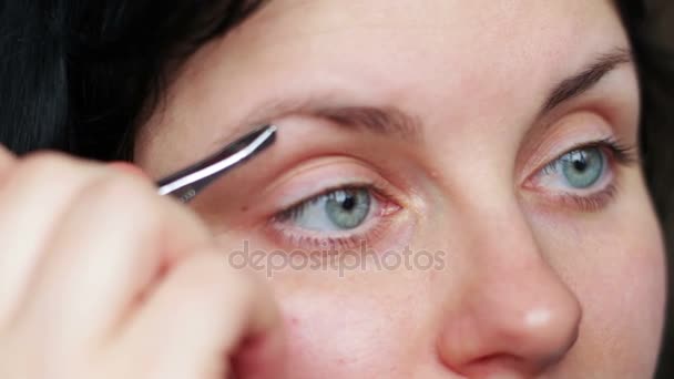 mujer arrancando cejas depilando con pinzas - Imágenes, Vídeo