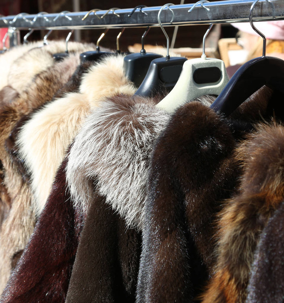 Szőrme kabátok és a ruhákat a fogas, a helyi piacon eladó - Fotó, kép