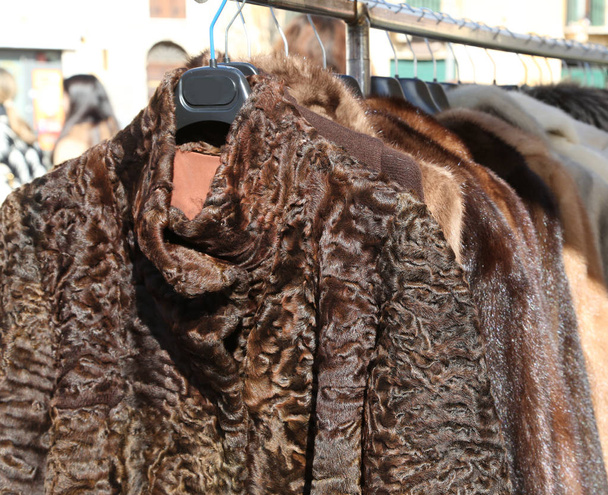 Pelzmäntel und Kleidung zum Verkauf im Kleiderbügel auf dem Flohmarkt - Foto, Bild