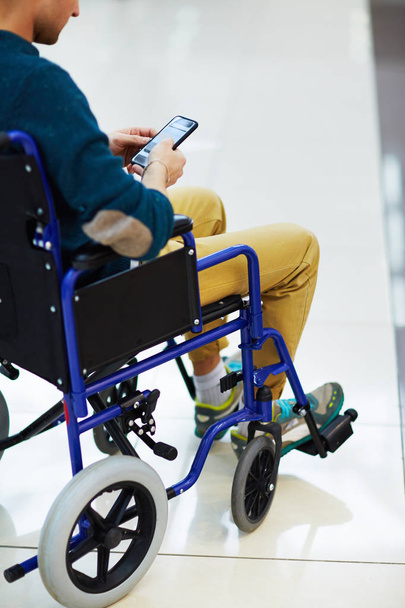 uomo seduto in sedia a rotelle e sms
 - Foto, immagini