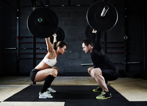 man and woman performing overhead squats - Zdjęcie, obraz