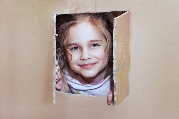 Little girl inside cardboard playhouse - Foto, Imagen