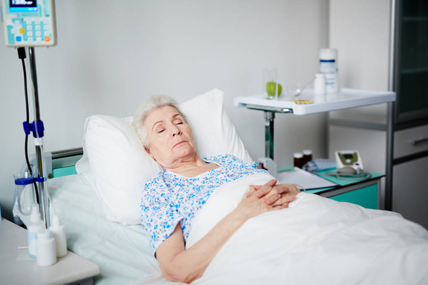 Senior woman asleep on bed - Photo, Image