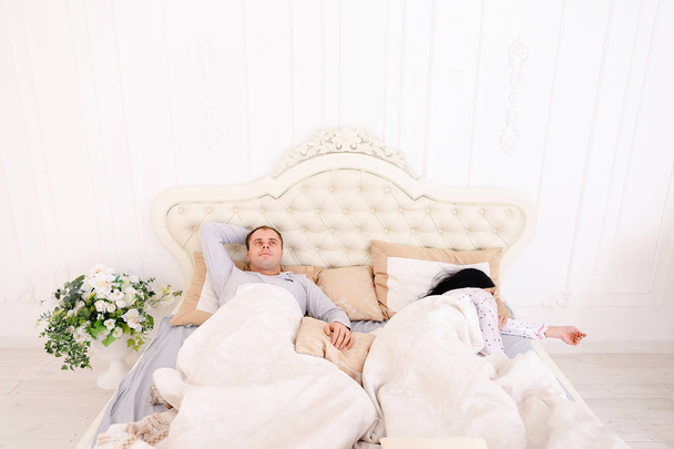 Homem não pode dormir na cama, pensando enquanto a esposa dorme
 - Foto, Imagem