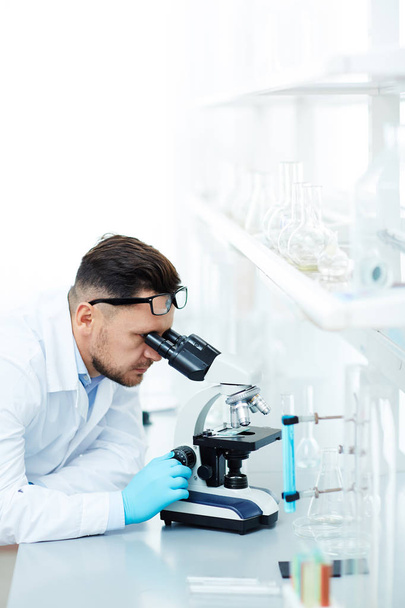 chemist looking in microscope - Фото, изображение