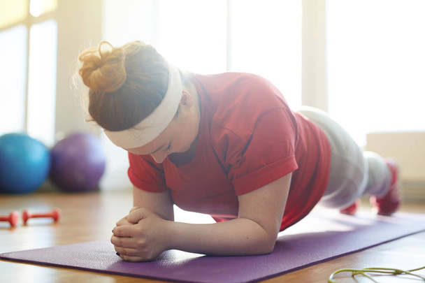 woman working out on yoa mat in studio - Valokuva, kuva