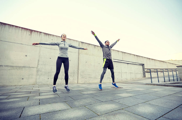 happy man and woman jumping outdoors - Foto, imagen