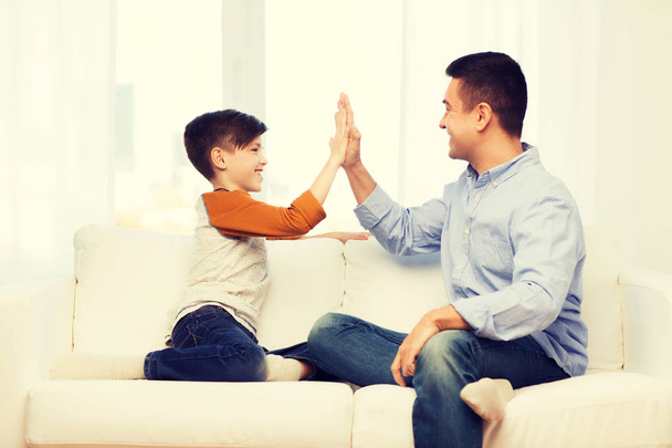 happy father and son doing high five at home - 写真・画像