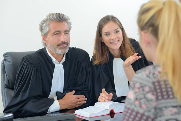 Legal workers in robes talking to client - Foto, Imagen