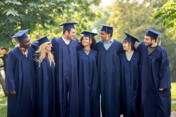 happy students or bachelors in mortar boards - Photo, Image