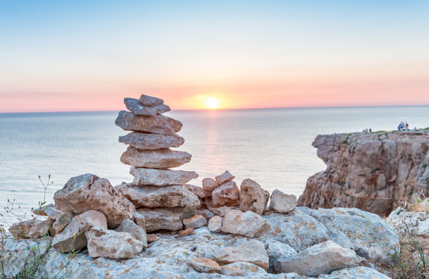 Ułożone kamienie morze o zachodzie słońca - Zdjęcie, obraz