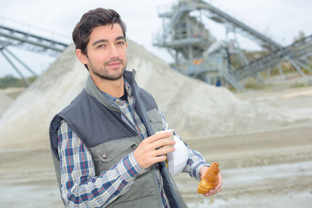 Portrait of man in quarry have breakfast on the hop - 写真・画像