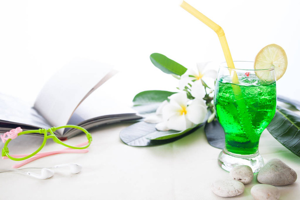 Напій зеленого кольору з льодом на білому тлі з квіткою сливи
, - Фото, зображення