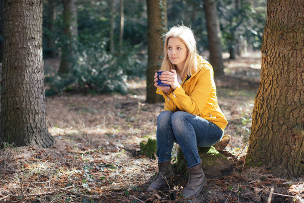 Hiker woman drinking from mug in forest.  - Photo, Image