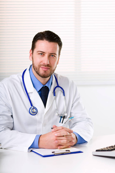 Homme médecin en manteau blanc avec stéthoscope sur le cou
 - Photo, image