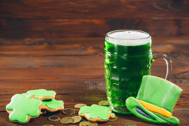 glass of green beer, coins and hat - Фото, изображение