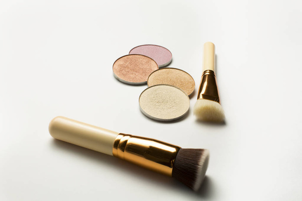 Kit of highlighters with cosmetic brushes over a white backgroun - Foto, imagen