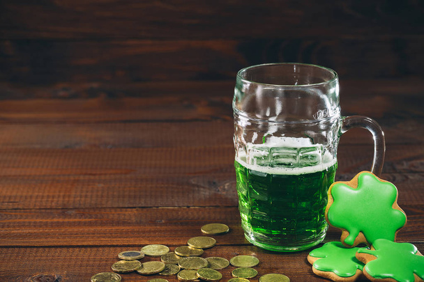 glass of green beer, coins and gingerbreads  - Zdjęcie, obraz