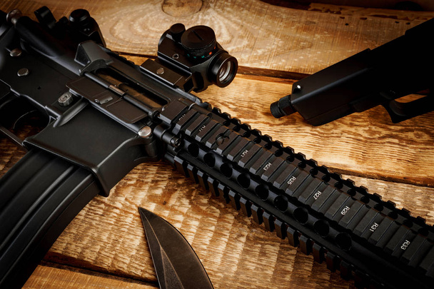 rifle de assalto em uma mesa de madeira
 - Foto, Imagem