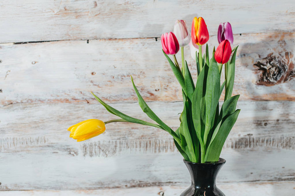 Tulipánok a vázában régi fából készült háttér - Fotó, kép