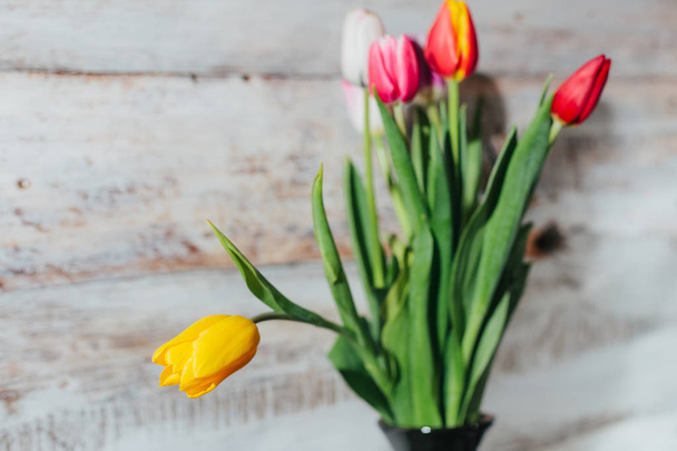 Old wooden background with tulips in vase - Photo, Image