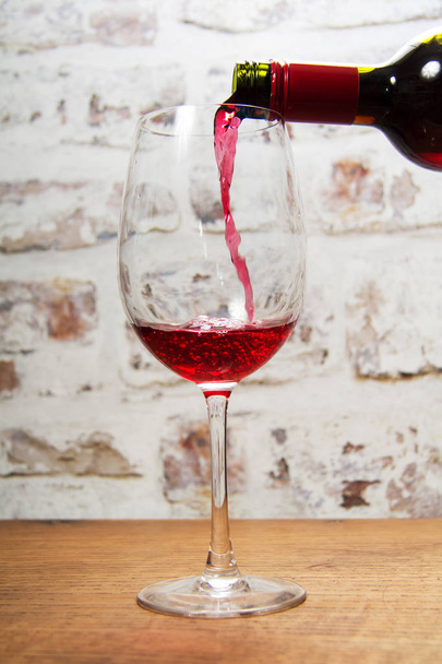 Наливается бокал красного вина
 - Фото, изображение