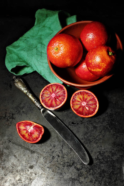 Ripe blood orange, cicilian orange on dark background with vintage knife - Photo, image