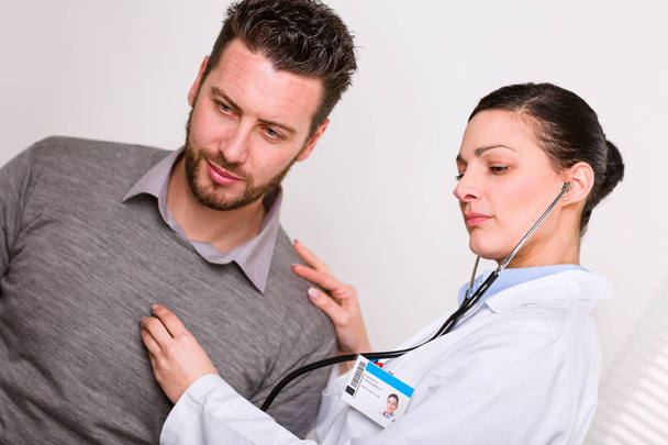 Young female doctor listening to a heartbeat - Zdjęcie, obraz