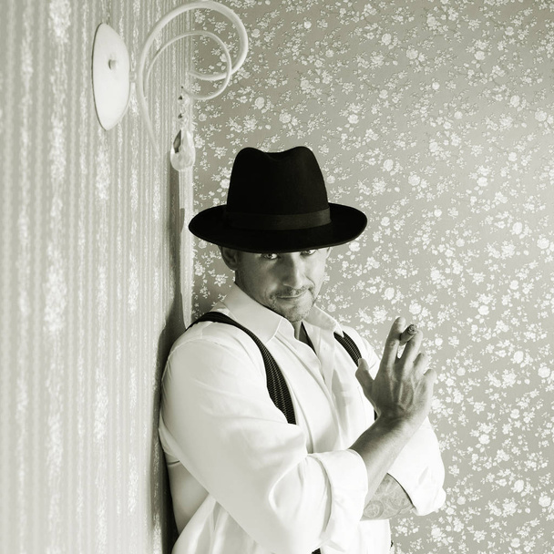 Muscular macho in a felt hat black and white photo - Foto, Imagen