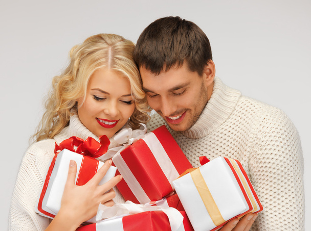 Romantic couple in a sweaters with gift boxes - Photo, image